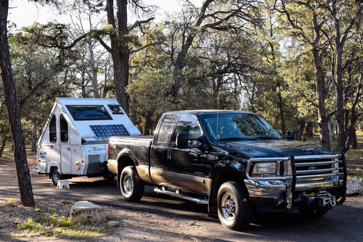 A black pickup truck and a camping trailer in a campground.