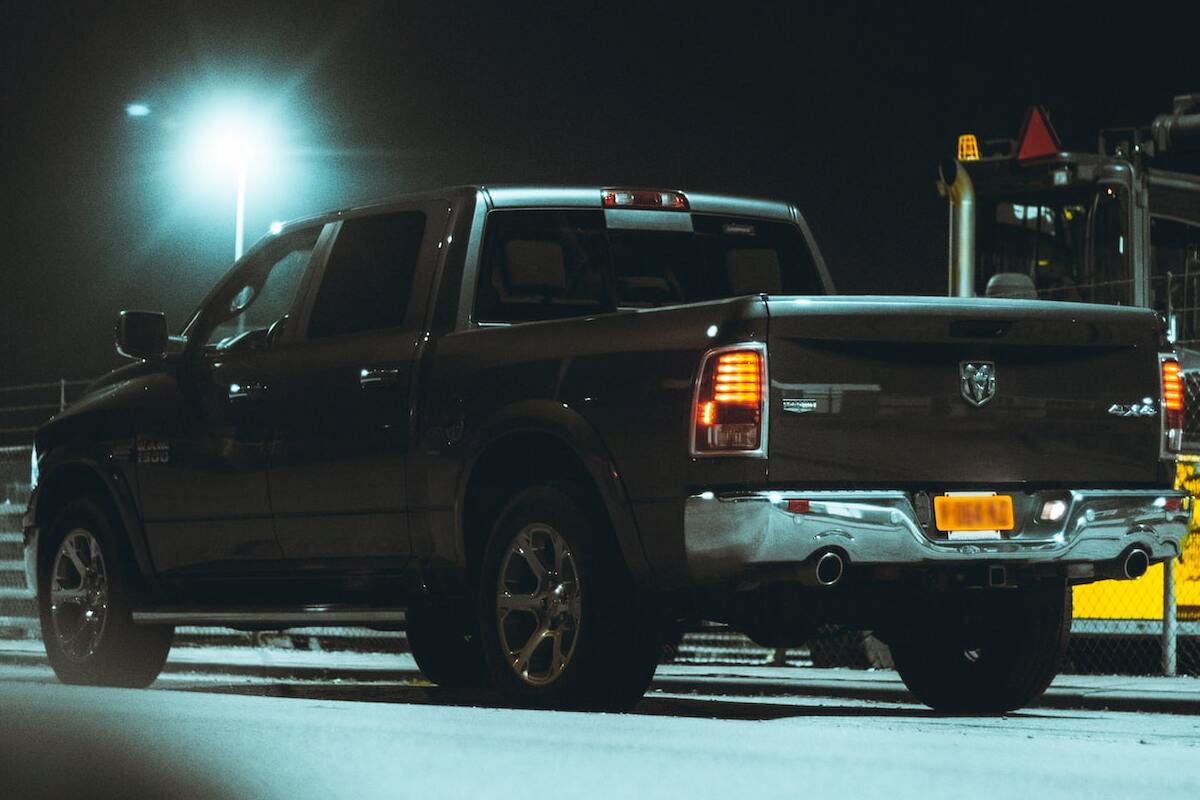 a black dodge ram 1500 in the middle of the road at night