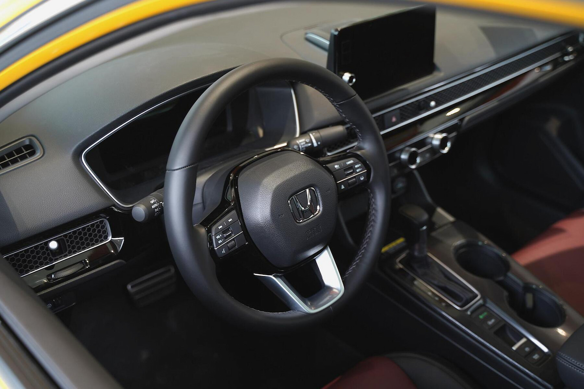 an interior of a honda car showing its steering wheel 