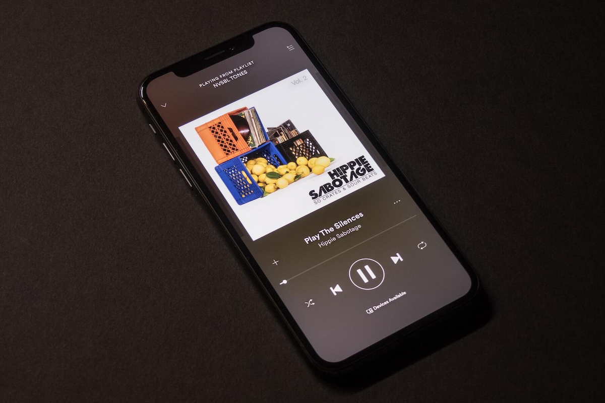 a song in a playlist is played in an iphone device in a dark background