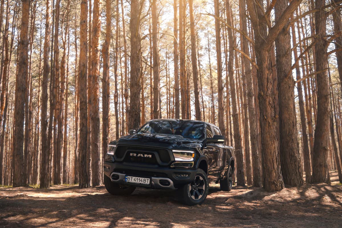 A black Dodge Ram in the forest.