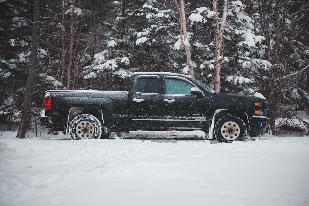 A black pickup truck is parked in the deep snow.