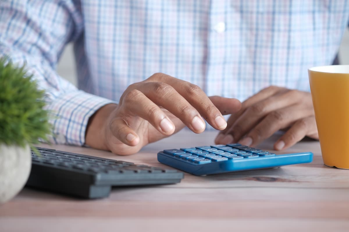 A man's hand using a calculator. 