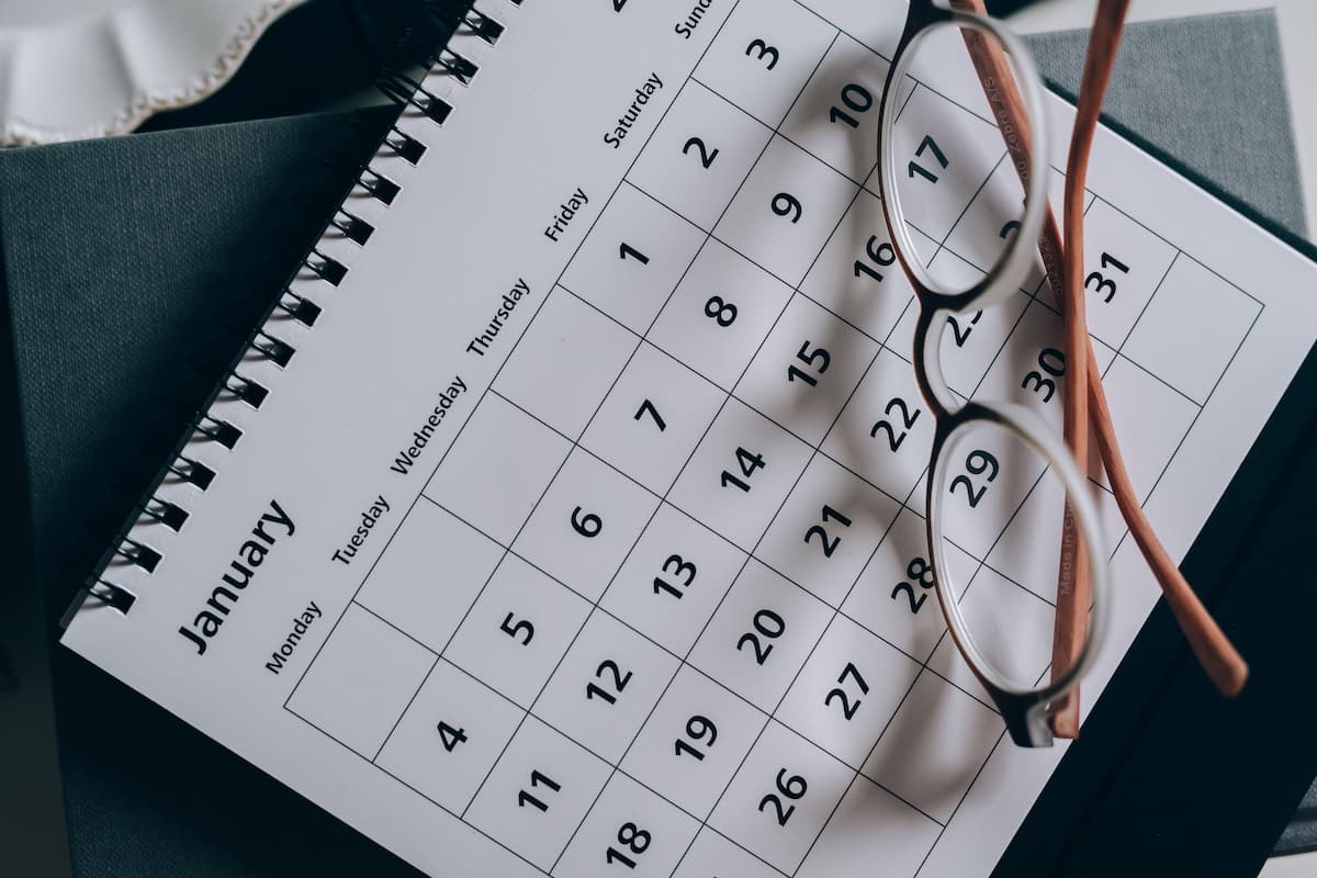 A calendar showing the month of January and eyeglasses on top of it. 