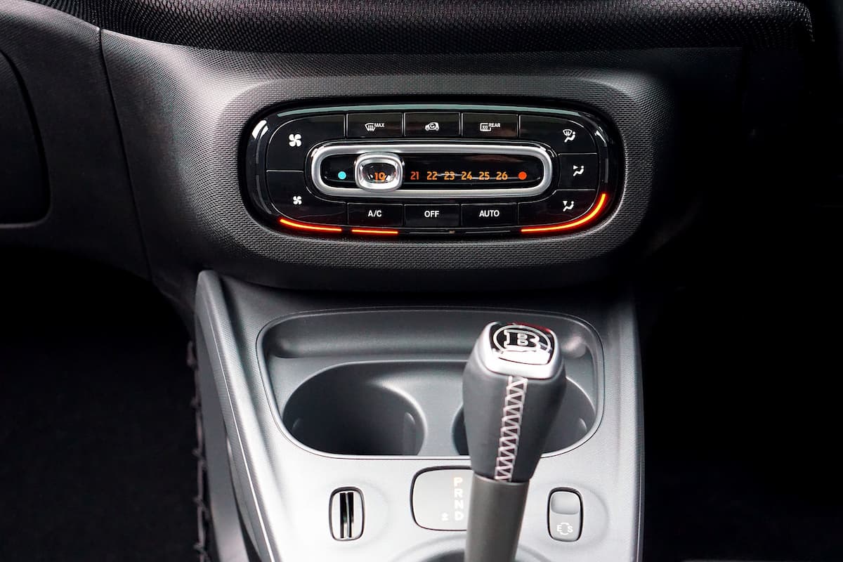 Photo of car's control panel with the air conditioner on and the gear stick.