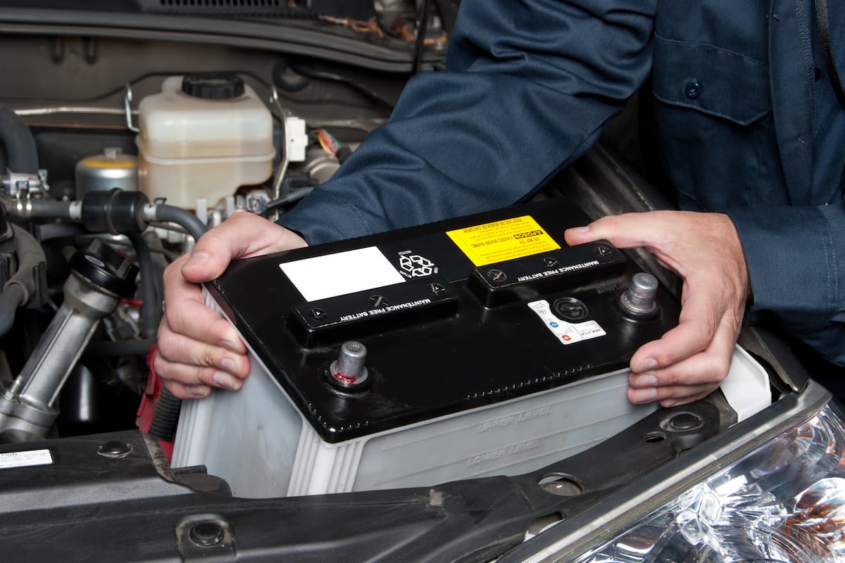 A mechanic replacing the car's battery. 