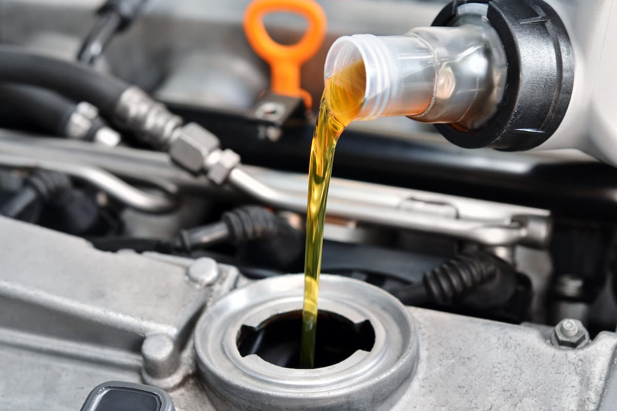 Motor oil is pouring into a car. 