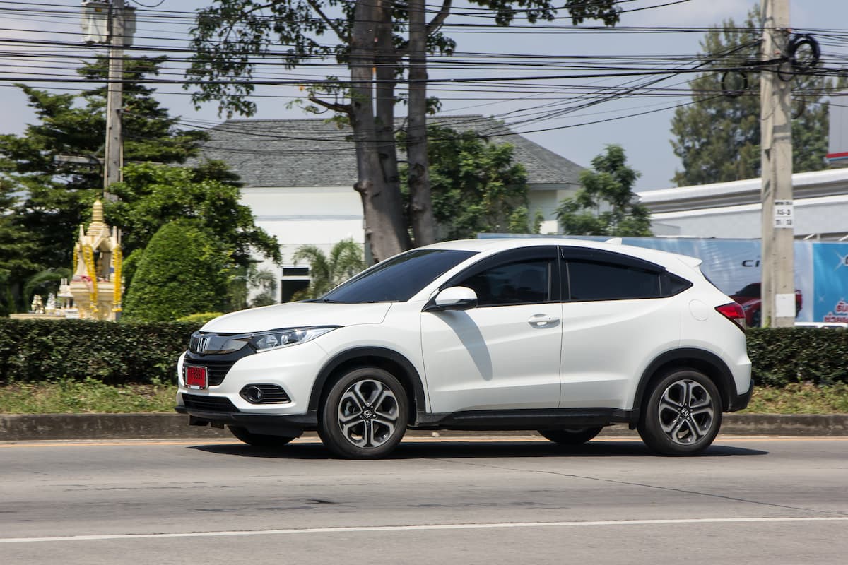 A white Honda HR-V on the road on a sunny day. 