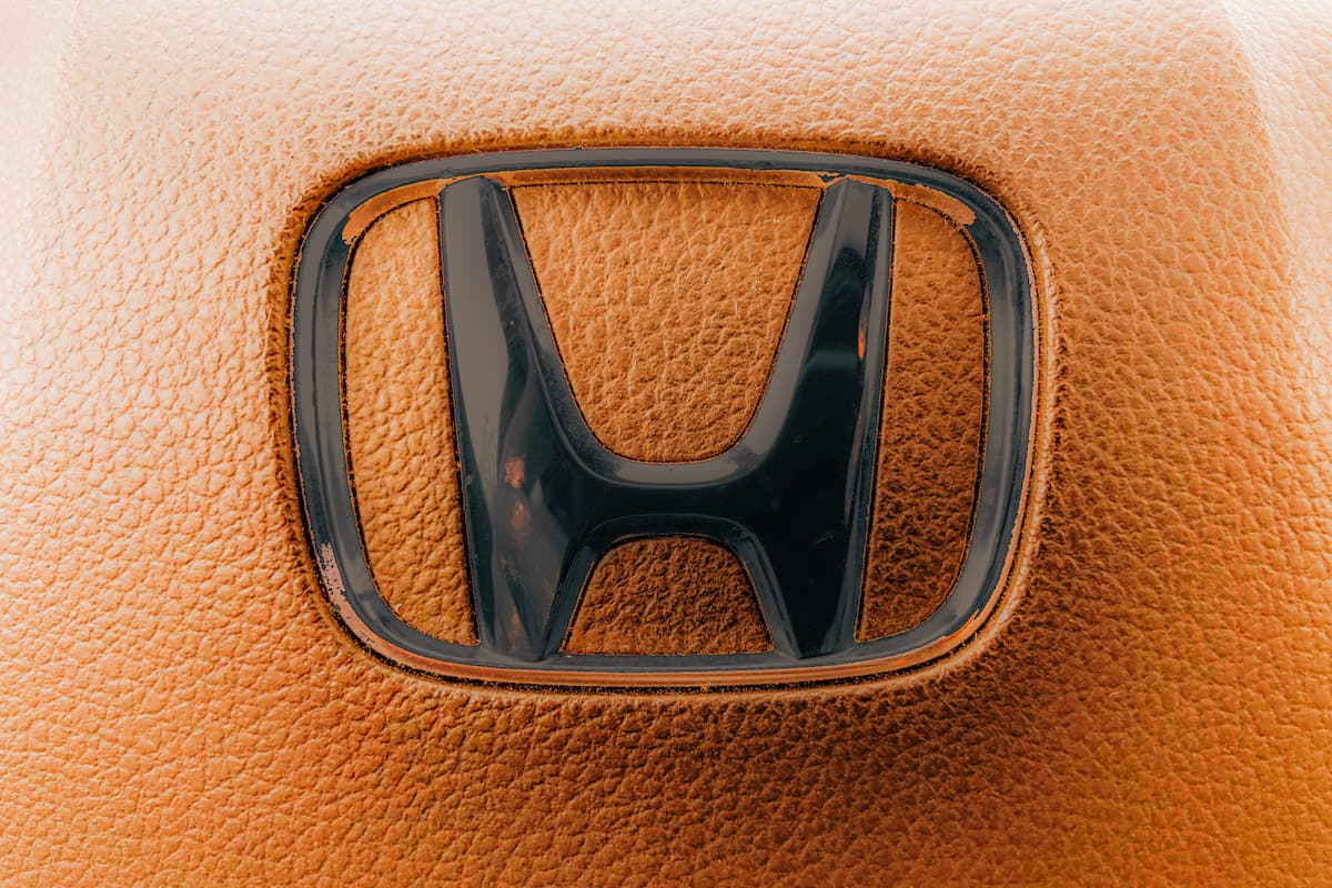 A logo of Honda is printed on brown leather. 