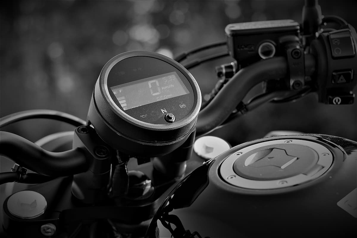 A black and white close-up photo of the Honda Rebel 500 speedometer and gas tank. 