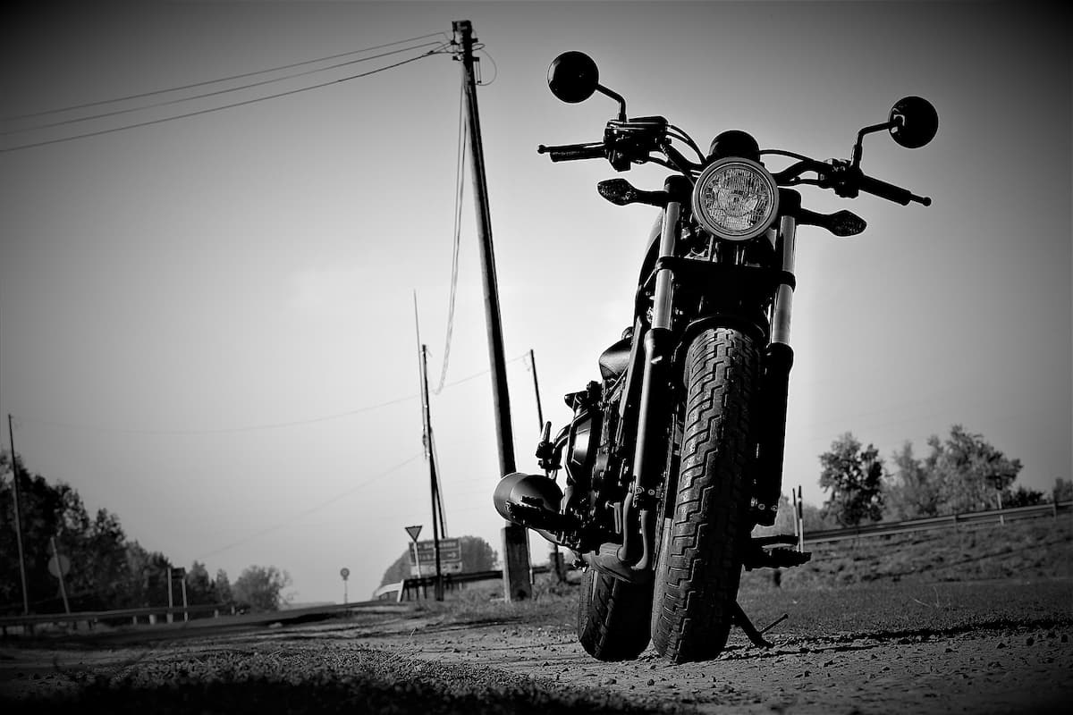 Black and white photo of Honda Rebel 500 parked on the side of the road. 