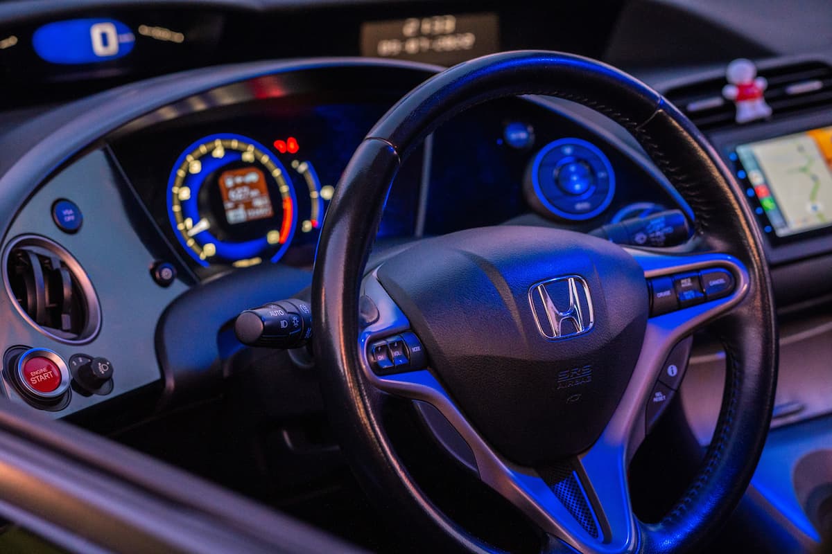The front interior of Honda car with the lights on.