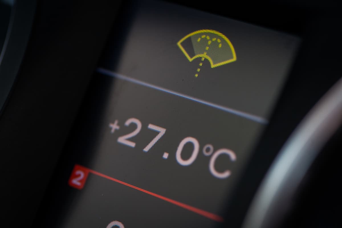 A close-up photo of a dash screen showing the temperature and low wash light warning.