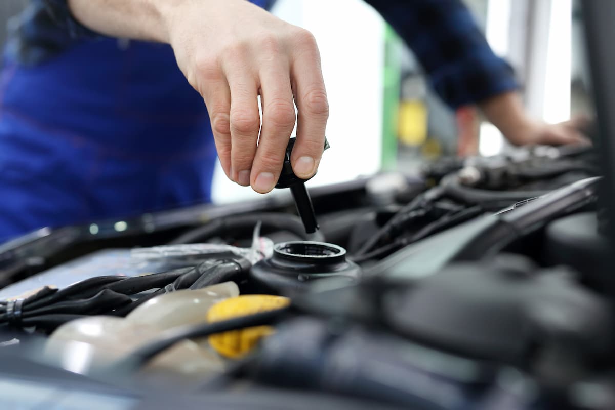 A mechanic changing the car's power steering fluid. 