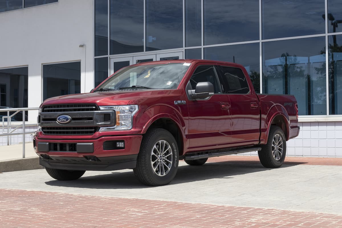 A red Ford F-150 is on display at a dealership. 