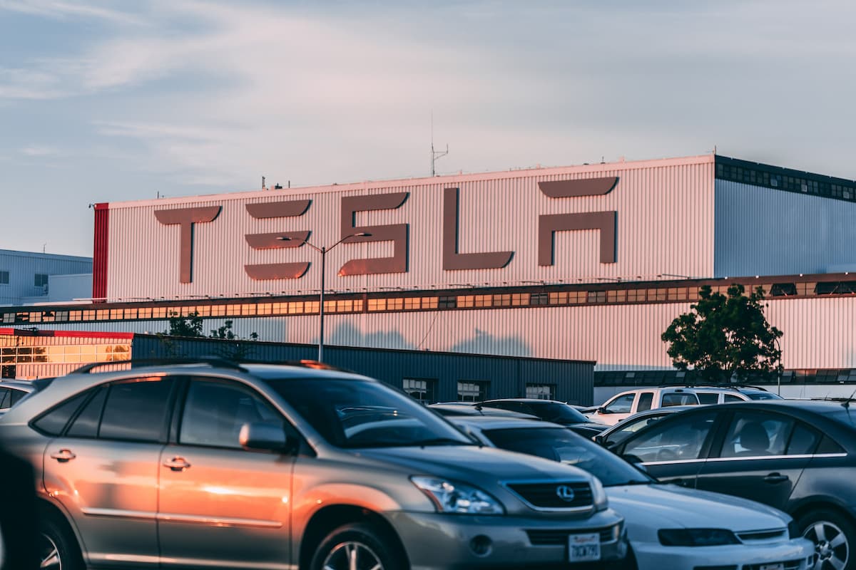 Photo of Tesla building with cars parked in front. 