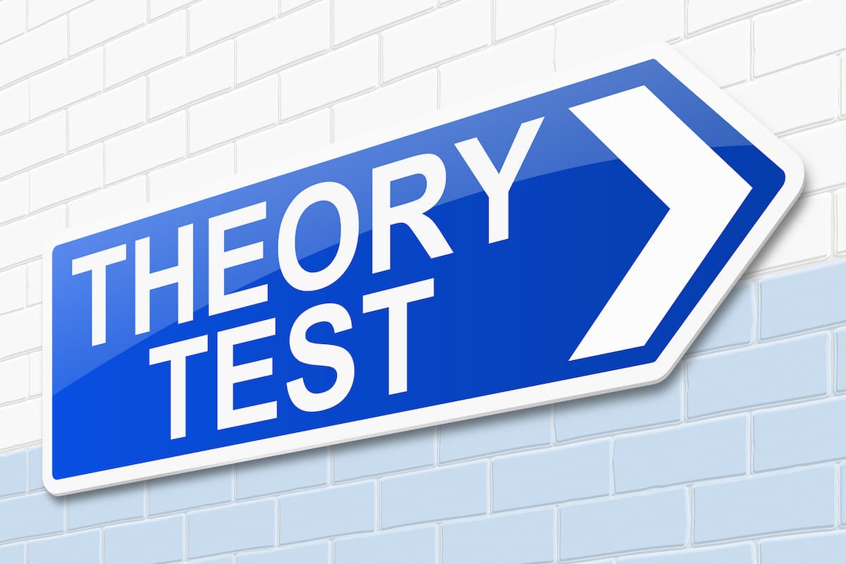 A sign with the concept of a Theory Test is illustrated.