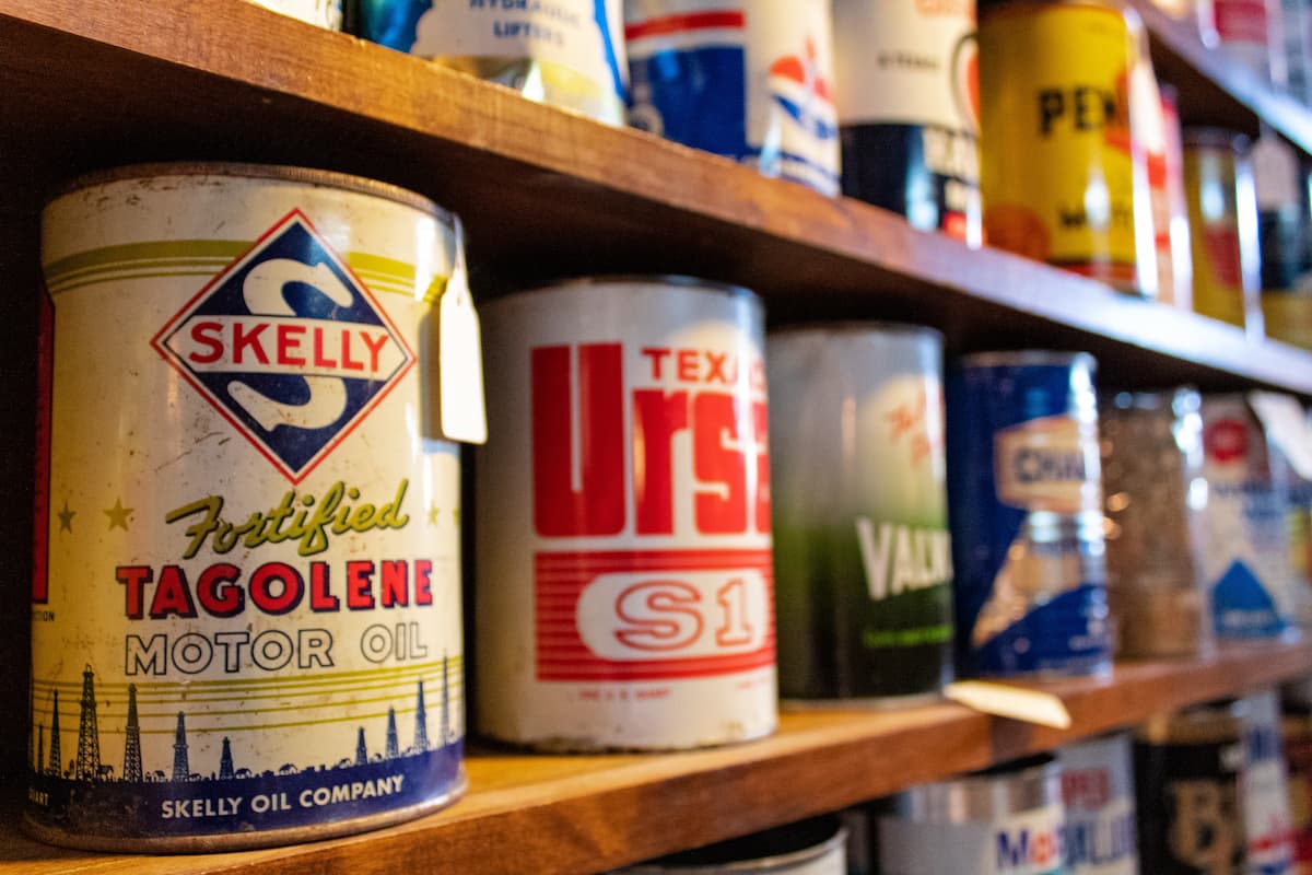 Cans of vintage motor oils on a shelf. 