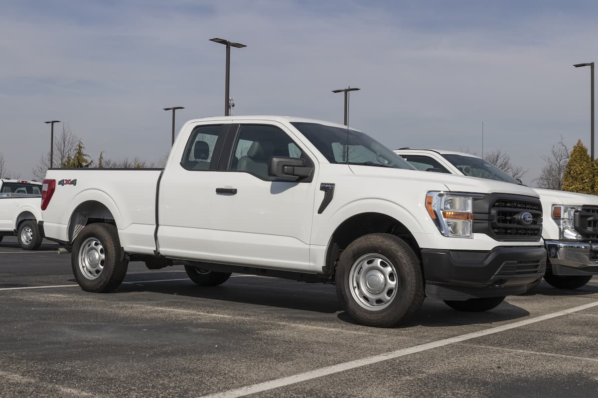 A white Ford F-150 is on display at a dealership.